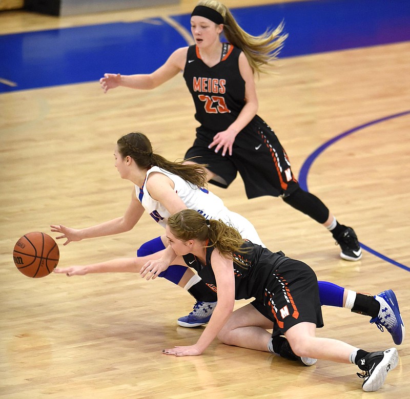 Cleveland's Emily Colbaugh (5) and Meigs County's Kaylie Moore (21) go after a loose ball as Meigs County's Cassidy Kenny (23) moves in.  The Meigs County Lady Tigers visited the Cleveland Lady Raiders in TSSAA girls basketball action during the Cleveland Holiday Tournament held on Friday December 30, 2016. 