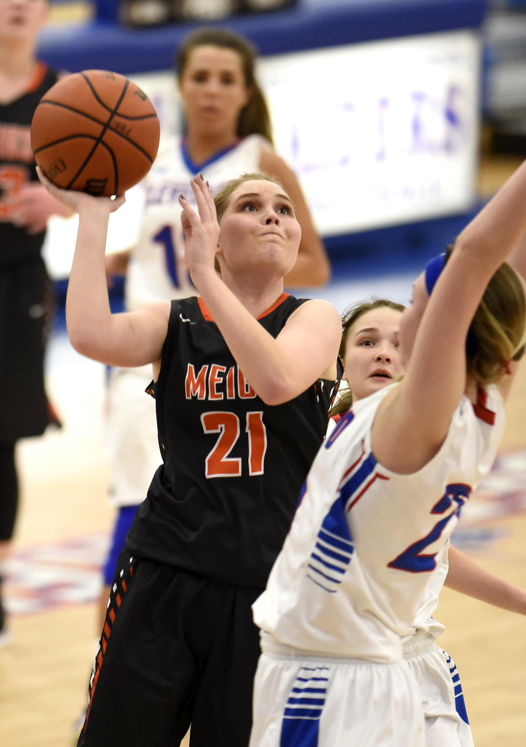 Meigs County's Kaylie Moore (21) scores over two Cleveland defenders. The Meigs County Lady Tigers visited the Cleveland Lady Raiders in TSSAA girls basketball action during the Cleveland Holiday Tournament held on Friday December 30, 2016.