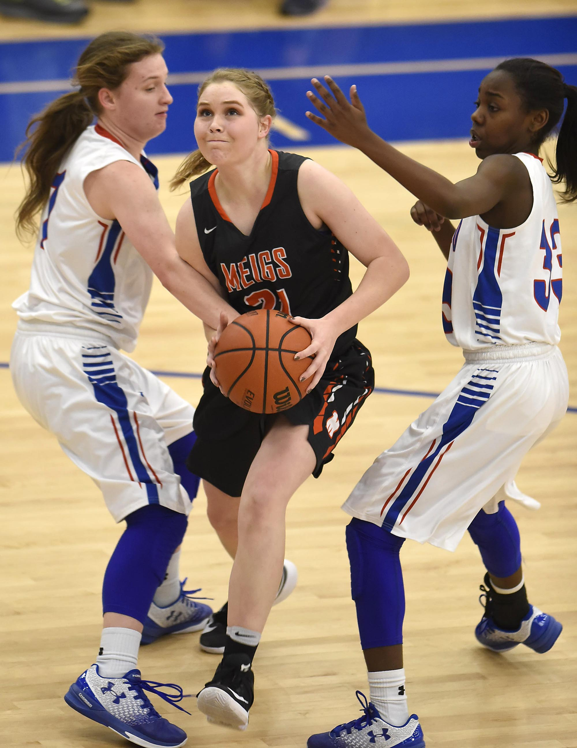 Meigs County's Kaylie Moore (21) drives between two Cleveland defenders on the way to scoring. The Meigs County Lady Tigers visited the Cleveland Lady Raiders in TSSAA girls basketball action during the Cleveland Holiday Tournament held on Friday December 30, 2016.