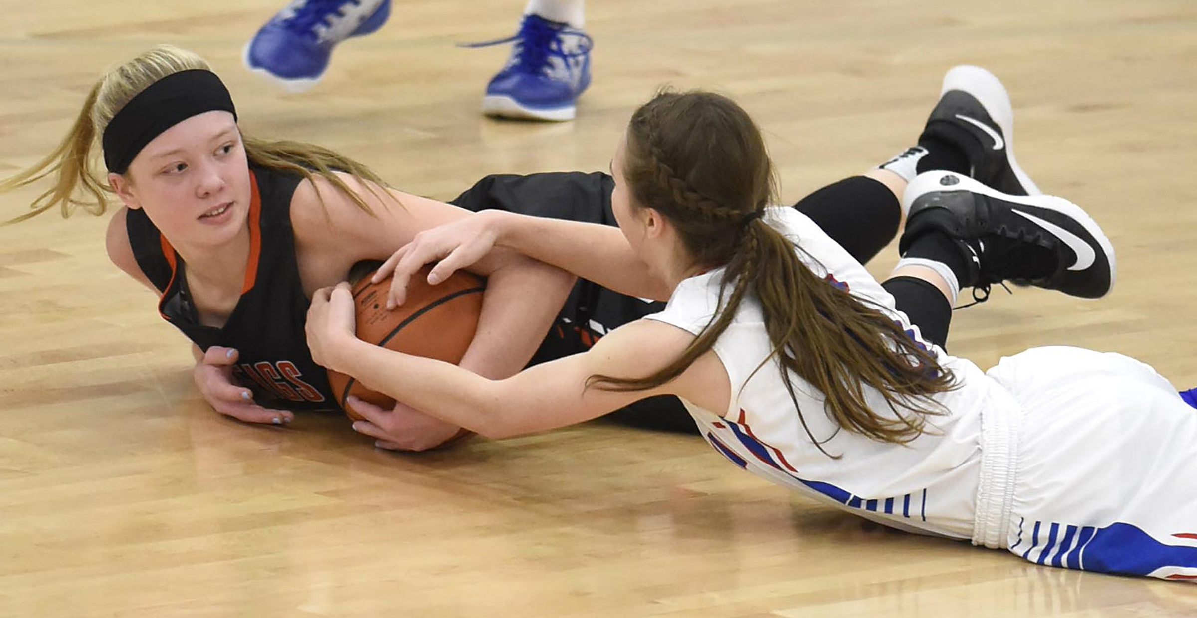 Meig's County's Cassidy Kenny (23) and Cleveland's Emily Colbaugh (5) go for a loose ball. The Meigs County Lady Tigers visited the Cleveland Lady Raiders in TSSAA girls basketball action during the Cleveland Holiday Tournament held on Friday December 30, 2016.
