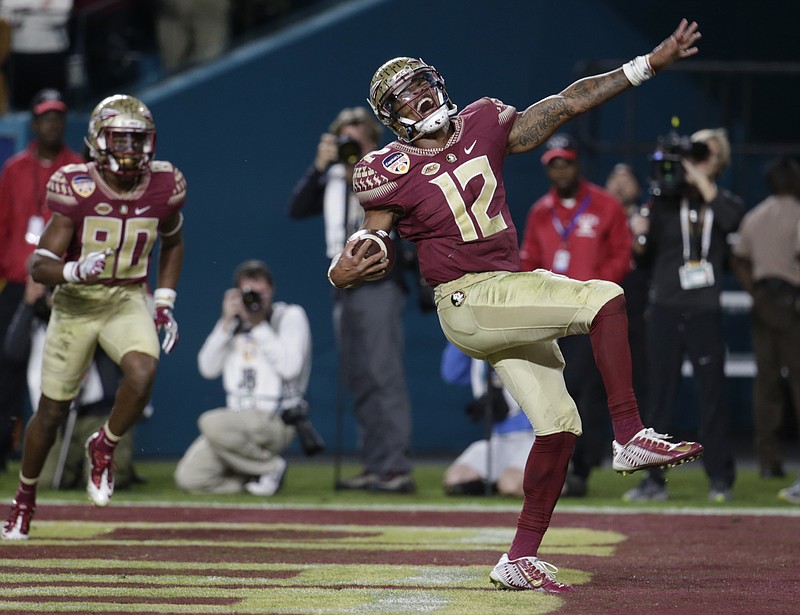 
              Florida State quarterback Deondre Francois (12) celebrates after scoring a touchdown, during the second half of the Orange Bowl NCAA college football game against Michigan, Friday, Dec. 30, 2016, in Miami Gardens, Fla. To the left is Florida State wide receiver Nyqwan Murray (80). (AP Photo/Lynne Sladky)
            