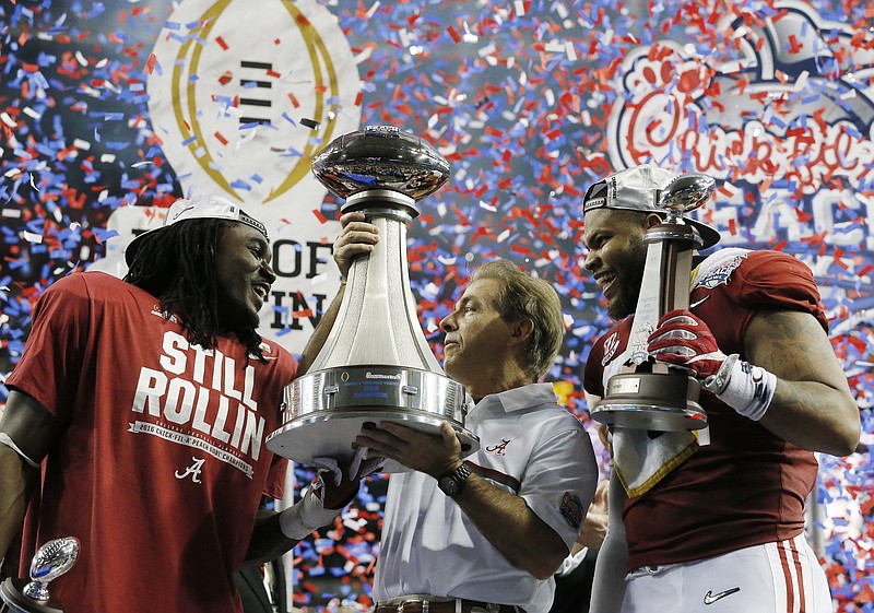 Offensive MVP running back Bo Scarbrough, left, head coach Nick Saban and defensive MVP linebacker Ryan Anderson, right, celebrate after Alabama's 24-7 Peach Bowl victory Saturday against Washington in Atlanta. The win put the Crimson Tide in the national championship game.