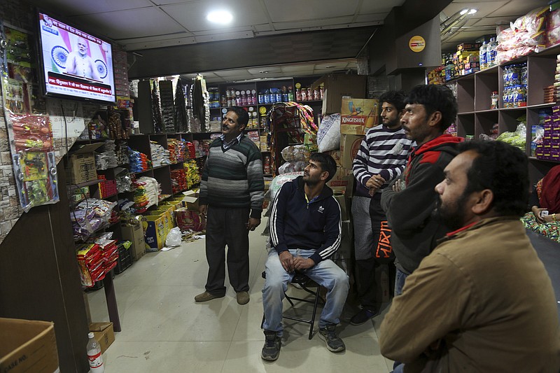 
              People watch Indian Prime Minister Narendra Modi addressing the nation, on television at a grocery store in Jammu, India, Saturday, Dec. 31, 2016. A day after the deadline for depositing old 500- and 1,000-rupee notes, Modi called the demonetization a purification drive during his Saturday speech. (AP Photo/Channi Anand)
            