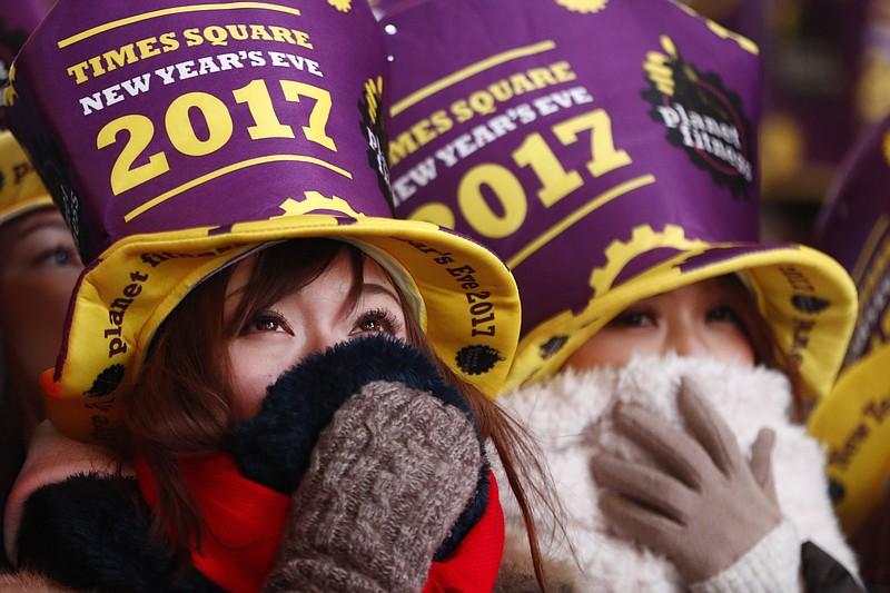 Revelers bundle up while gathered at Times Square during a New Year's Eve celebration Saturday, Dec. 31, 2016, in New York. (AP Photo/Julio Cortez)