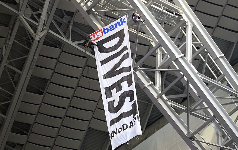 
              Protesters against the Dakota Access Pipeline rappel from the catwalk in U.S. Bank Stadium during the first half of an NFL football game between the Minnesota Vikings and the Chicago Bears, Sunday, Jan. 1, 2017, in Minneapolis. (AP Photo/Andy Clayton-King)
            