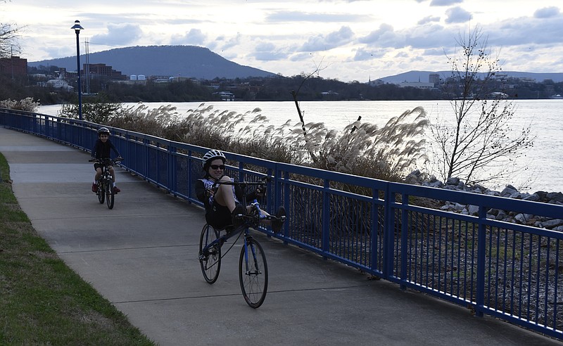 Valerie Russak, right, bicycles on the Tennessee Riverwalk with her son Bennett Russak. The scene captures at least three of the elements participants will learn in Outdoor Chattanooga's upcoming Learn To Ride a Bicycle class: the kind of bicycle the elder Russak is riding, rules for greenway riding and the importance of helmets.