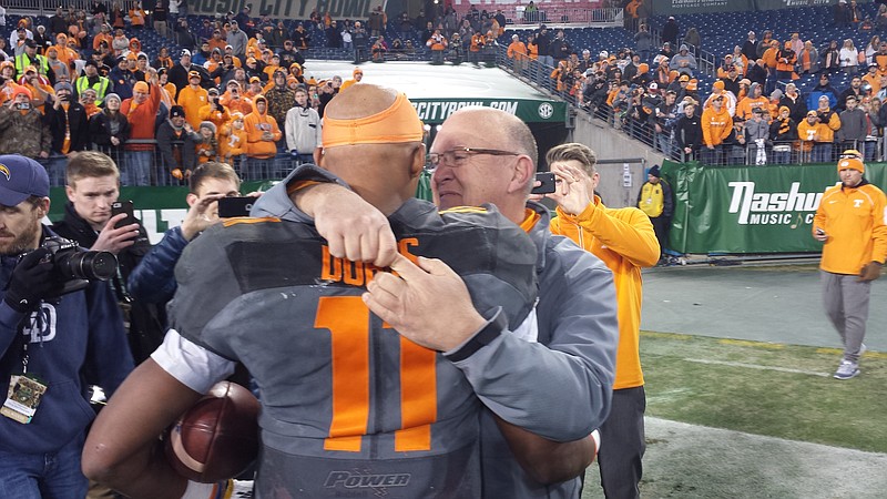 Tennessee quarterback Josh Dobbs and offensive coordinator Mike DeBord hug following the Vols' 38-24 victory against Nebraska in Nashville in the final game of Dobbs's career.