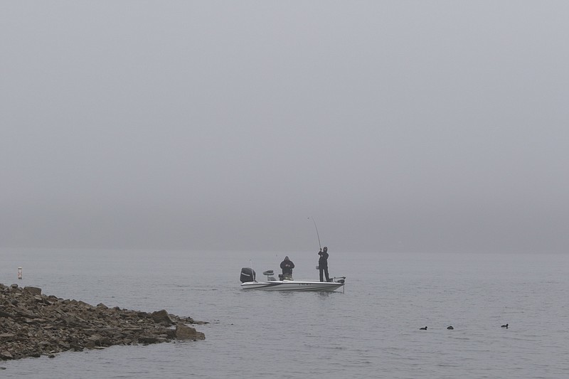 Fishermen work the bank while trolling on the Tennessee River near Chickamauga Dam as fog fills the Tennessee Valley on Monday, Jan. 2, 2017.