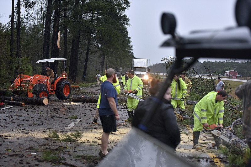 Crews work to remove downed trees and debris on Highway 49 South in Covington County, Miss., near Collins, Monday, Jan. 2, 2017. Forecasters say damaging winds, hail and flash flooding will be possible on Monday as a storm system moves across the South. (Elijah Baylis/The Clarion-Ledger via AP)