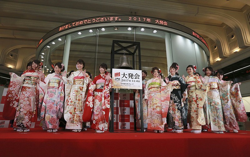 
              Kimono-clad employees of the Tokyo Stock Exchange and models wave from the stage after a ceremony marking the start of this year's trading in Tokyo Wednesday, Jan. 4, 2017. Japanese languages at top read: "Happy New Year!" (AP Photo/Eugene Hoshiko)
            
