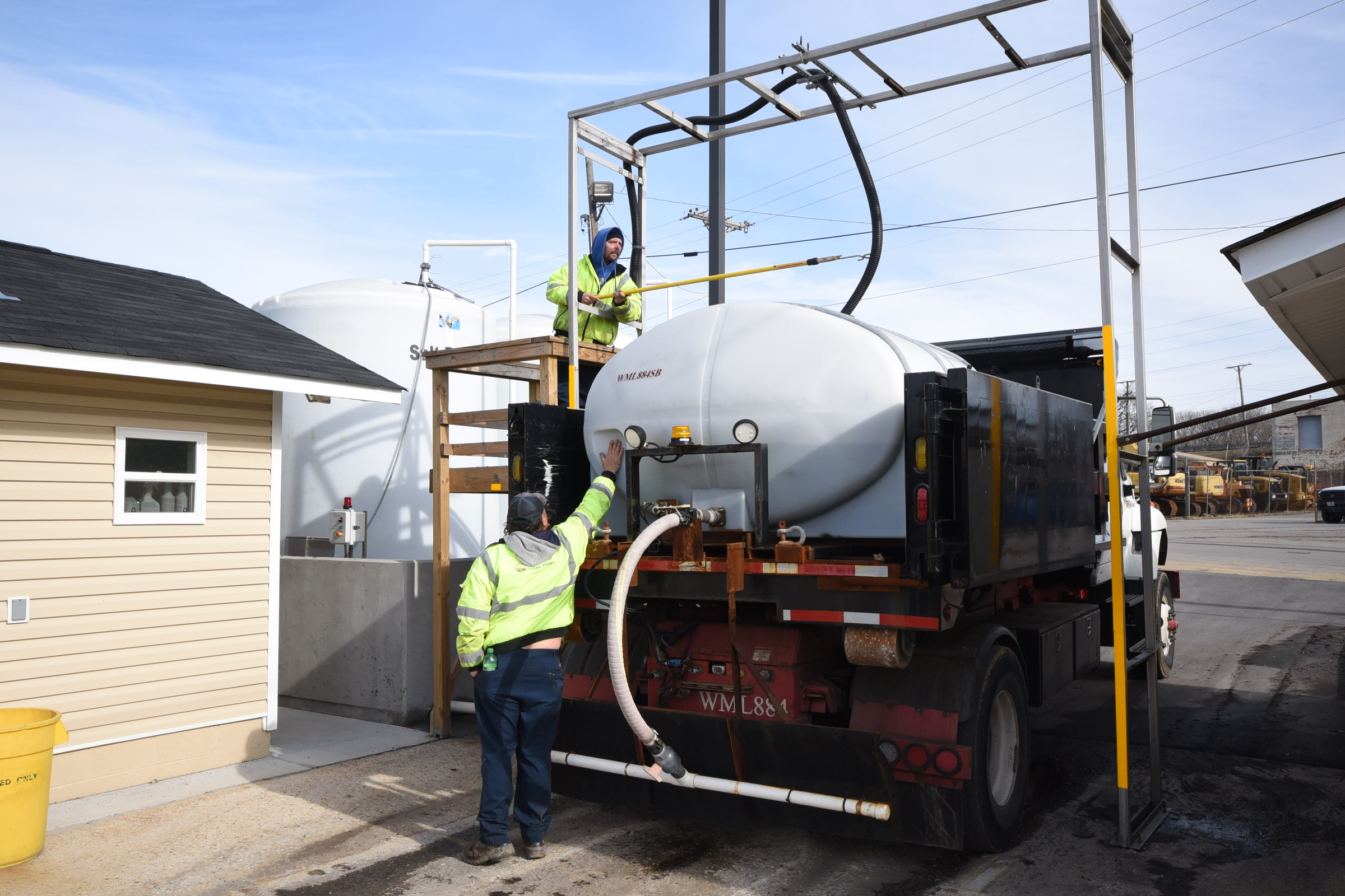 William Dunston, top, andJesse Harvey prep and fill the first city brine truck with nearly 1,000 gallons Wednesday afternoon at the city yard near E. 11th Street.