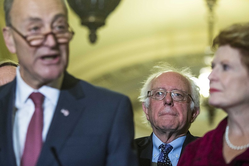 Sen. Bernie Sanders, (I-Vt.), who was just named Chair of Outreach on the Senate Democratic leadership team, listens beside Senate Minority Leader Chuck Schumer (D-N.Y.), left, and Sen. Debbie Stabenow (D-Mich.), right. (Al Drago/The New York Times)