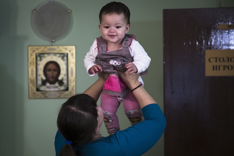 Lilya Rakheyeva plays with her daughter Anyuta at an Orthodox Christian emergency shelter in Moscow, Russia.