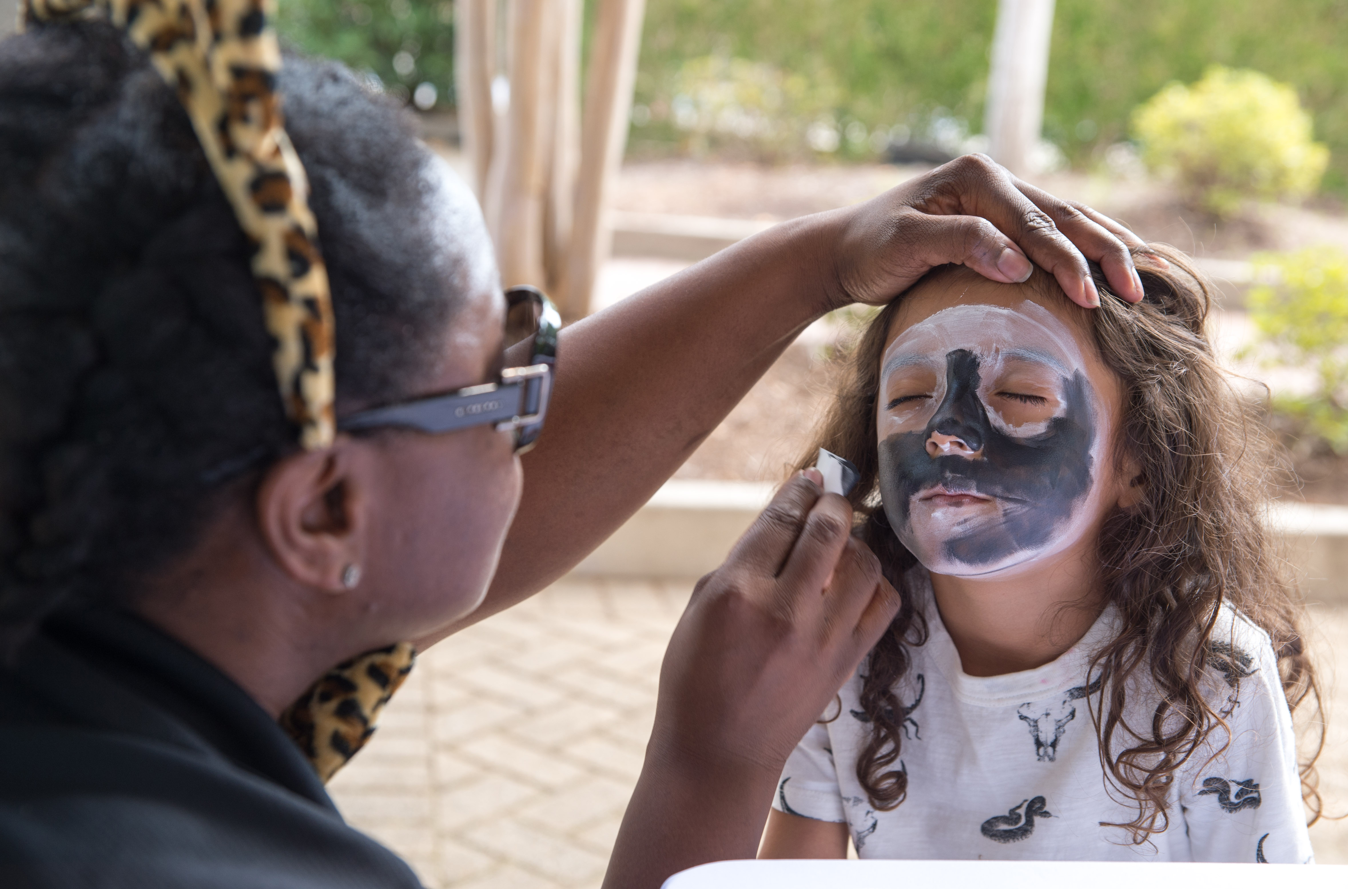 Tamira Henry paints Jade Palacio’s face.