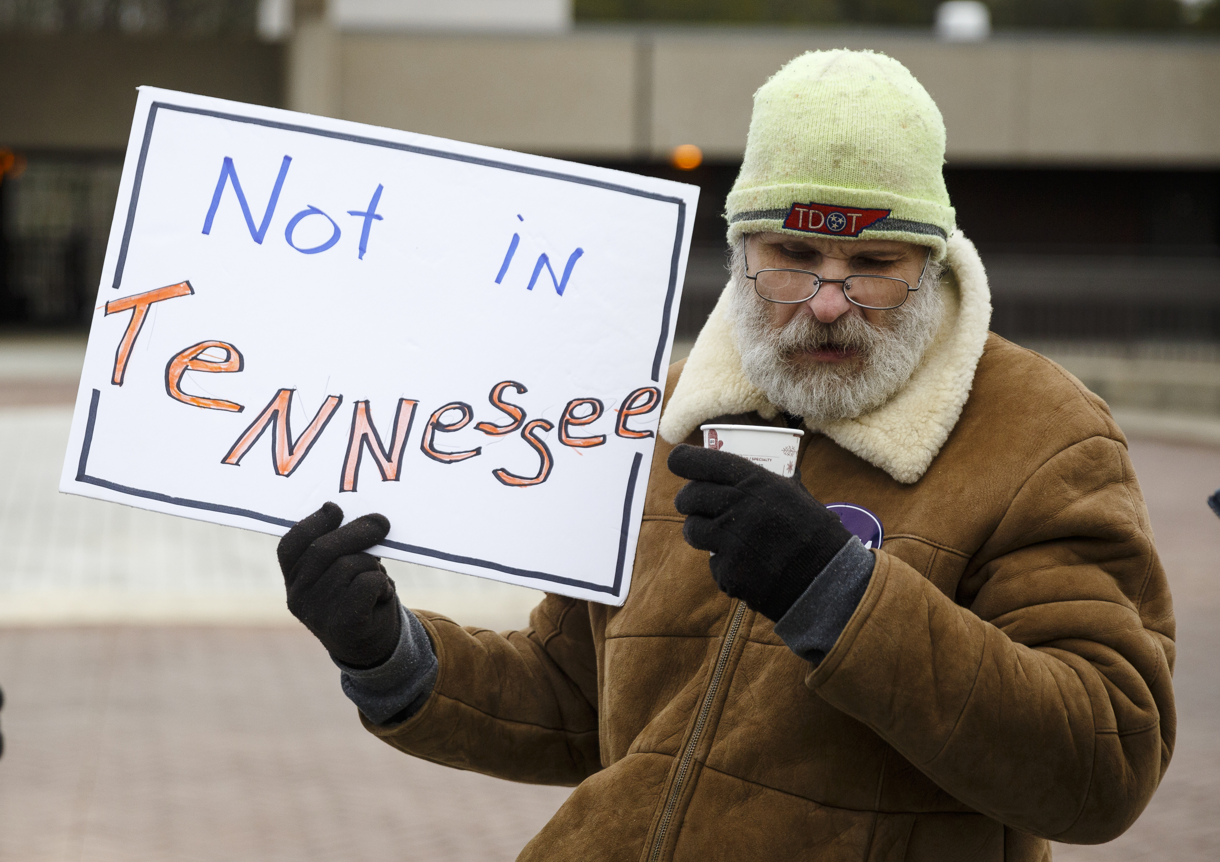 Derrick Williams holds a sign with demonstrators protesting the privatization of the Fall Creek Falls State Park's hospitality services outside of the park's inn on Thursday, Jan. 5, 2017, near Spencer, Tenn. The Tennessee State Employees Association organized the protest, which coincided with a meeting by state officials and potential bidders at the park's inn.