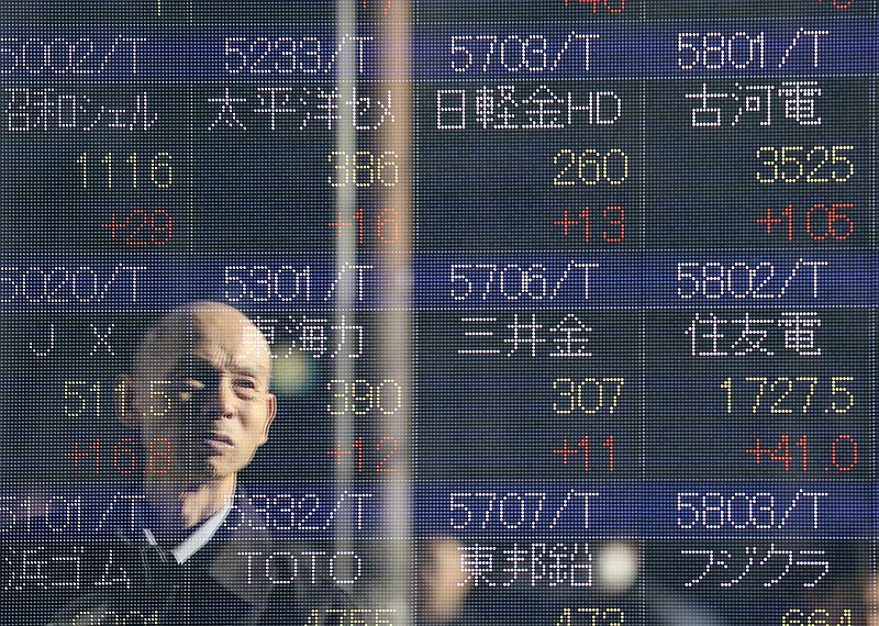 
              A man is reflected on the electronic board of a securities firm in Tokyo,Wednesday, Jan. 4, 2017. Asian shares were mixed Wednesday, as the Tokyo benchmark jumped in the first trading of 2017, helped by a weak yen. Other indexes lost some gains from earlier this week. (AP Photo/Koji Sasahara)
            