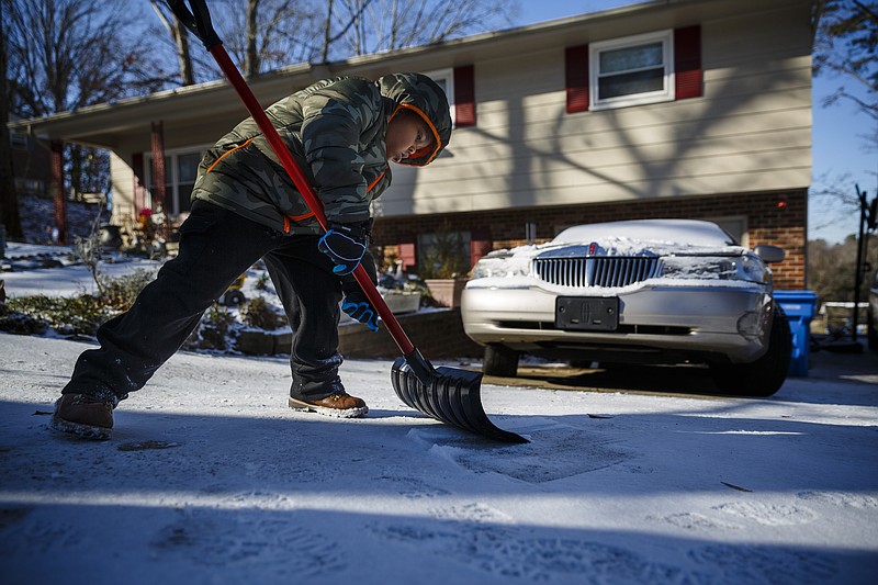 Jaden Trammell helps shovel snow from his grandfather's driveway after an overnight winter storm brought snow to the region Saturday, Jan. 7, 2017, in Chattanooga, Tenn. Icy roads caused headaches for motorists as the temperatures dropped into the teens overnight.