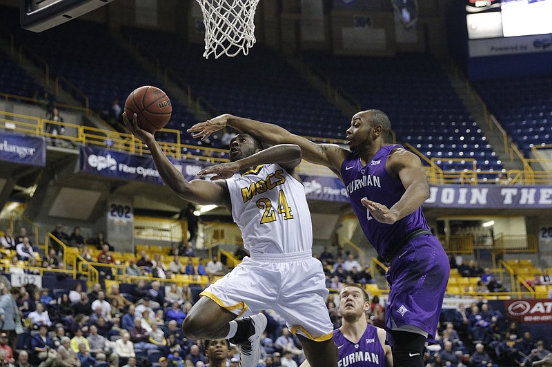 UTC guard Casey Jones hits a basket around a block by Furman forward Jalen Williams during the Mocs' home basketball game against Furman at McKenzie Arena on Saturday, Jan. 7, 2017, in Chattanooga, Tenn.