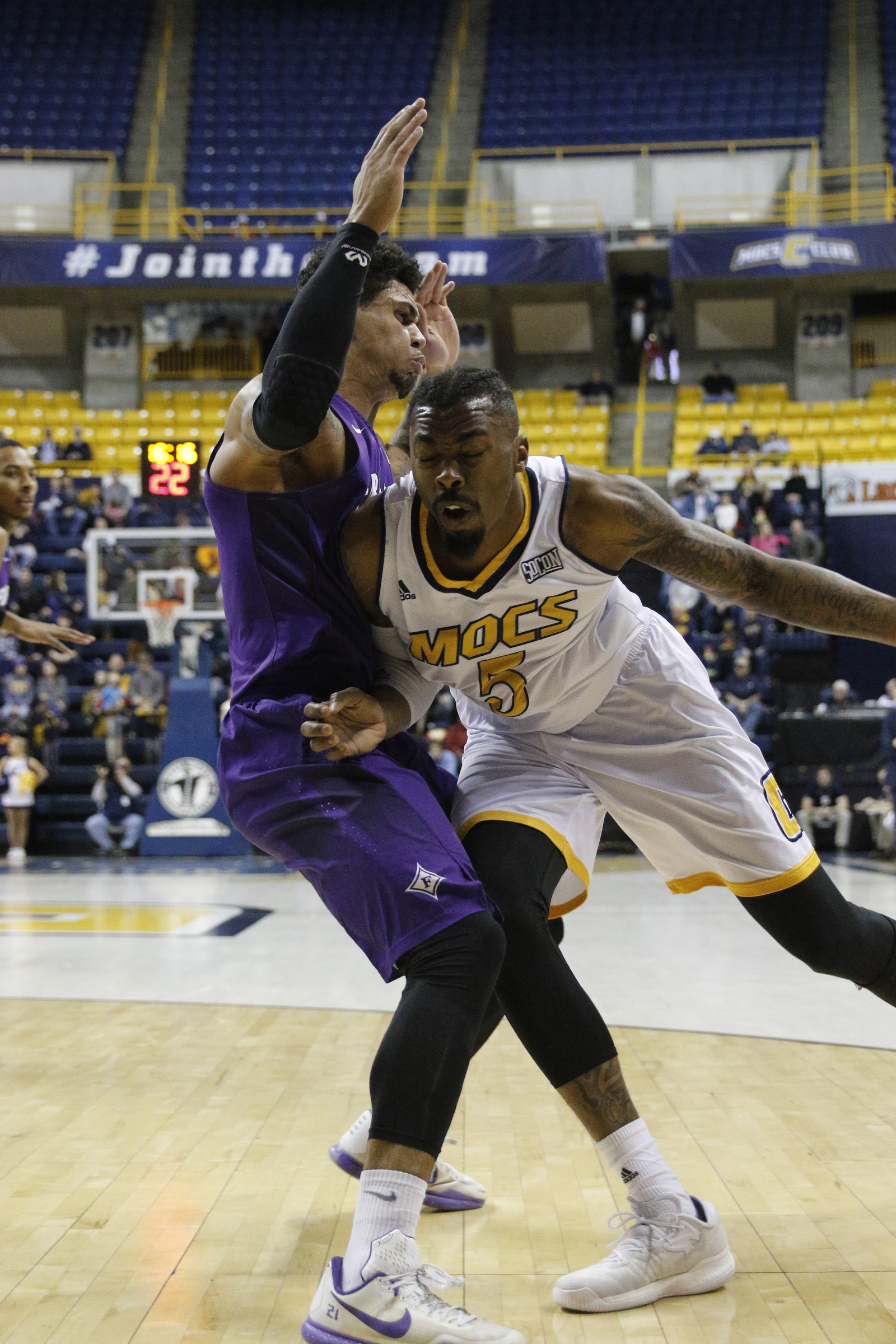 UTC forward Justin Tuoyo charges Furman forward Kris Acox during the Mocs' home basketball game against Furman at McKenzie Arena on Saturday, Jan. 7, 2017, in Chattanooga, Tenn.