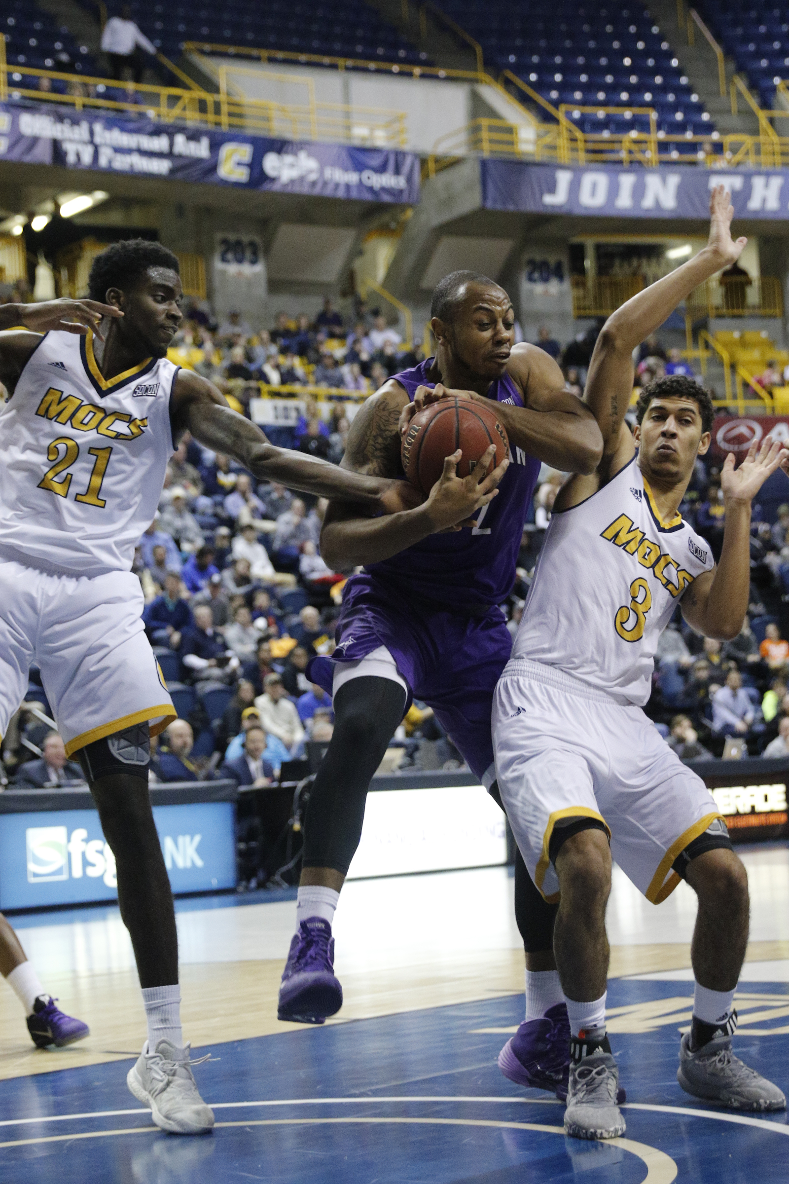 Furman forward Jalen Williams rebounds ahead of UTC guard Nat Dixon, right, and forward Makinde London during the Mocs' home basketball game against Furman at McKenzie Arena on Saturday, Jan. 7, 2017, in Chattanooga, Tenn.