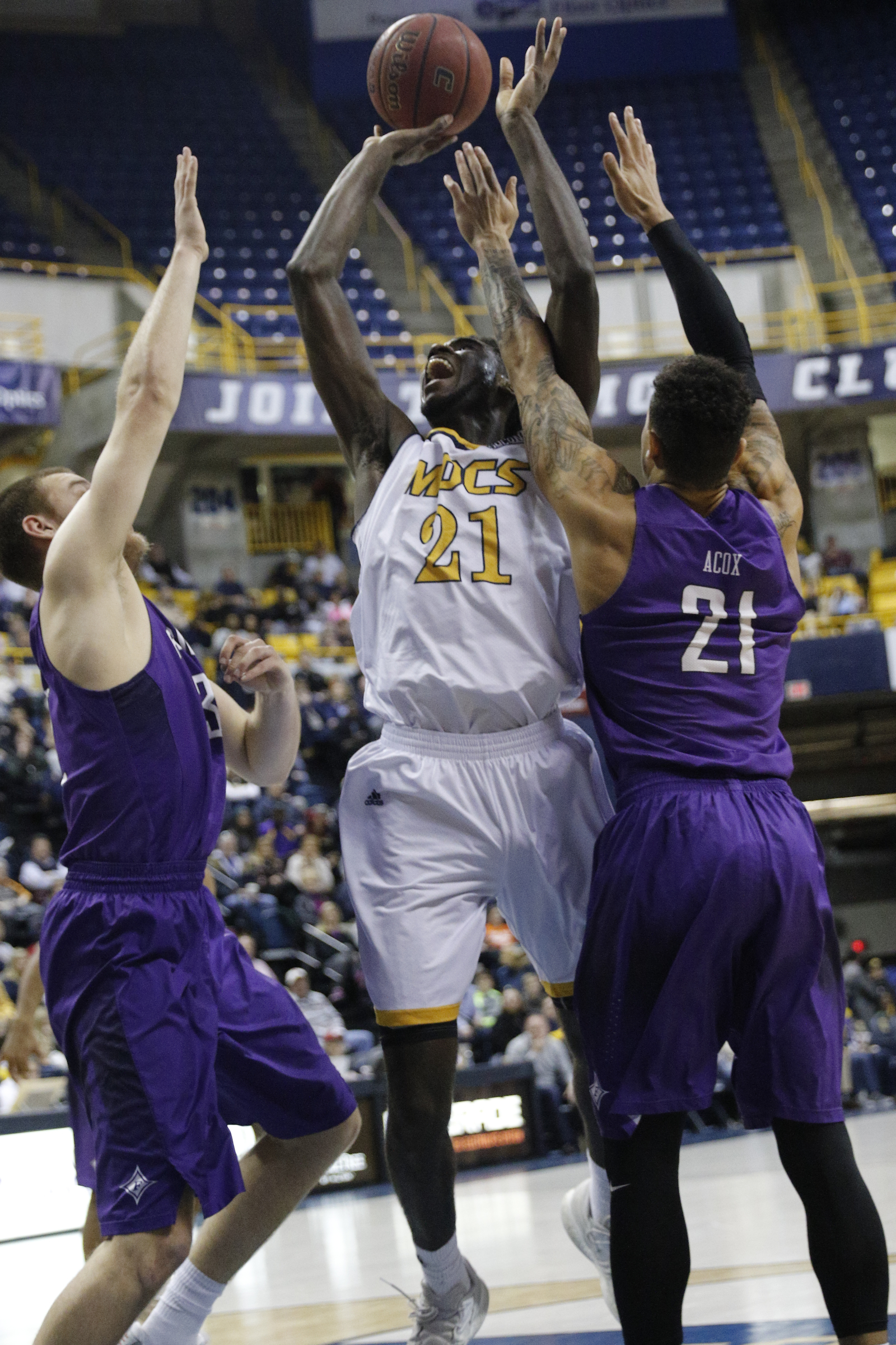 UTC forward Makinde London shoots between Furman forward Kris Acox, right, and forward Geoff Beans, left, during the Mocs' home basketball game against Furman at McKenzie Arena on Saturday, Jan. 7, 2017, in Chattanooga, Tenn.