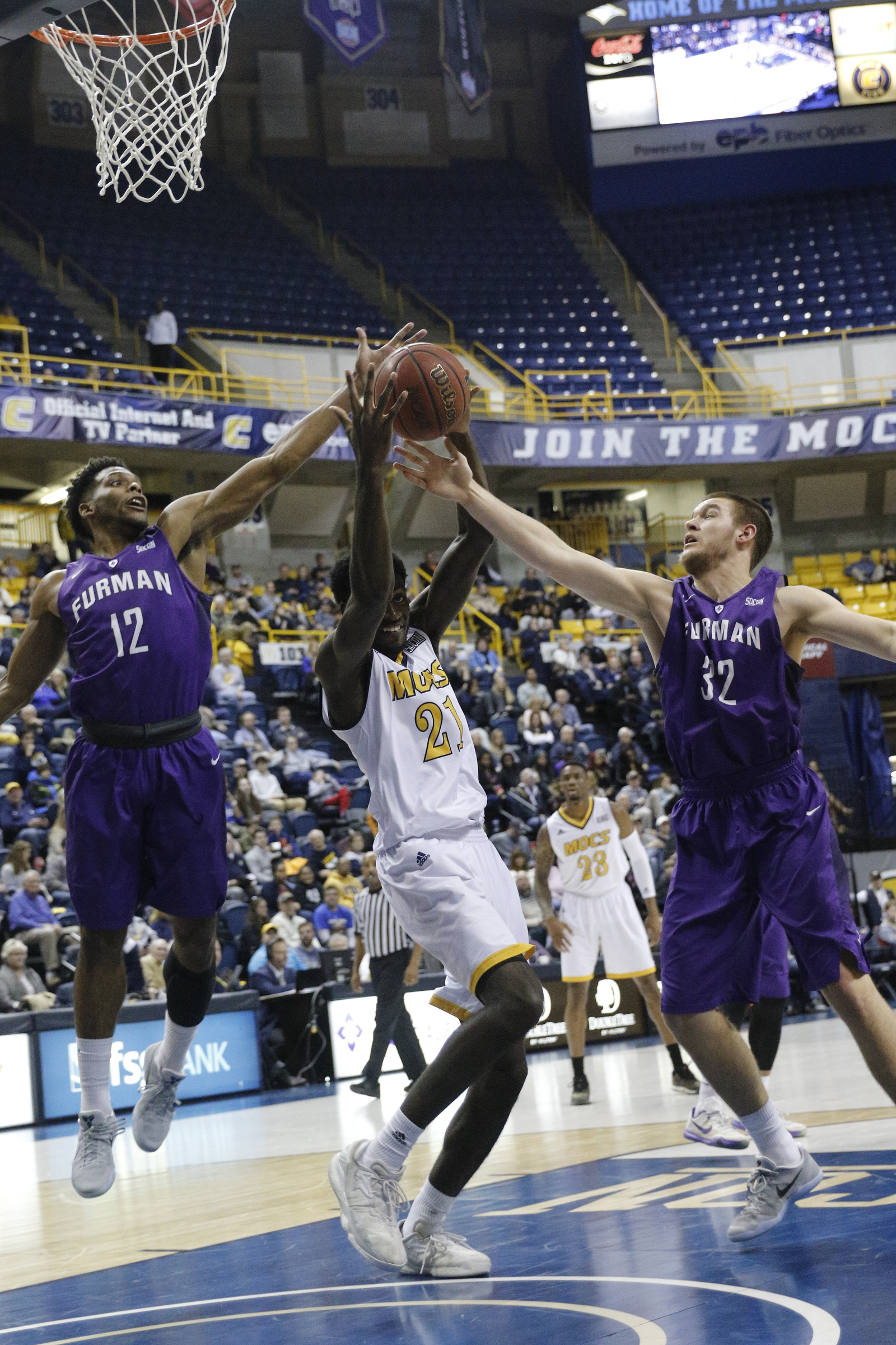 UTC forward Makinde London beats Furman forward Devin Sibley (12) and forward Matt Rafferty (32) to the rebound during the Mocs' home basketball game against Furman at McKenzie Arena on Saturday, Jan. 7, 2017, in Chattanooga, Tenn.
