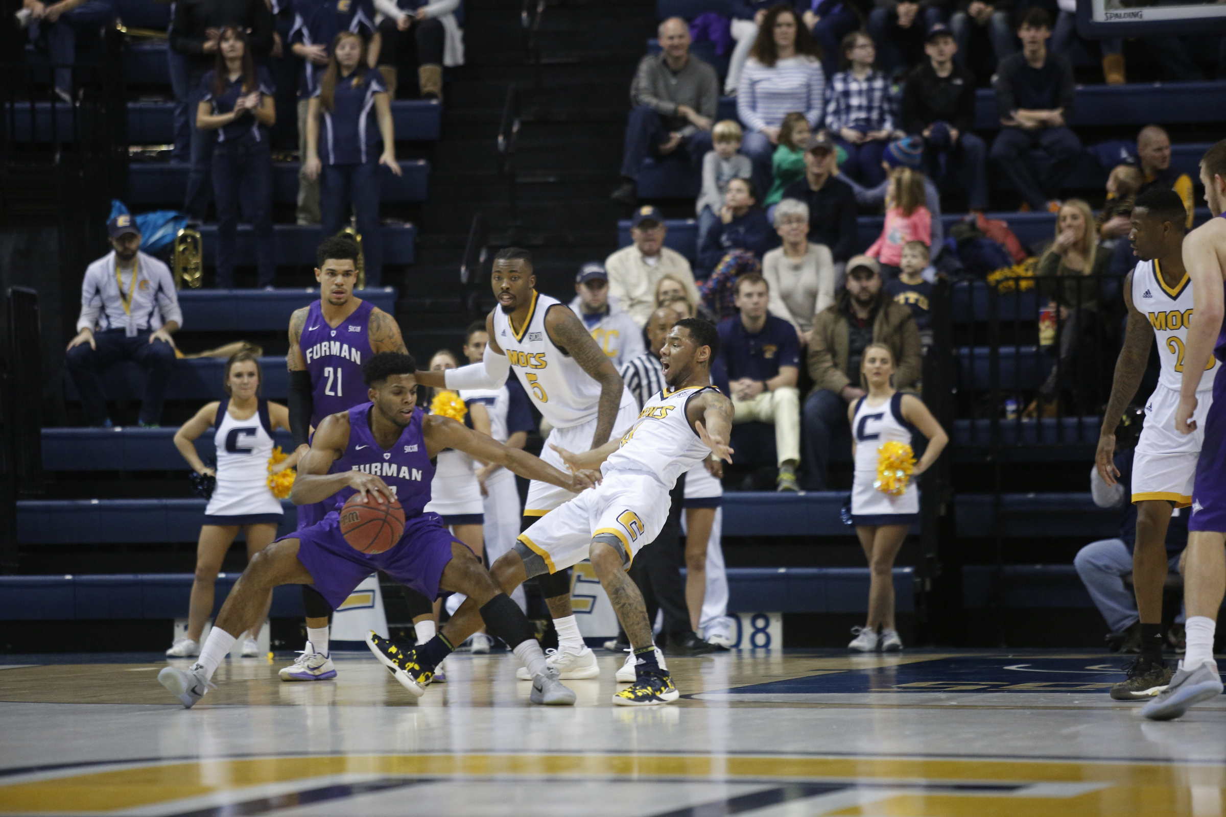 Furman forward Devin Sibley knocks down UTC guard Jonathan Burroughs-Cook during the Mocs' home basketball game against Furman at McKenzie Arena on Saturday, Jan. 7, 2017, in Chattanooga, Tenn.