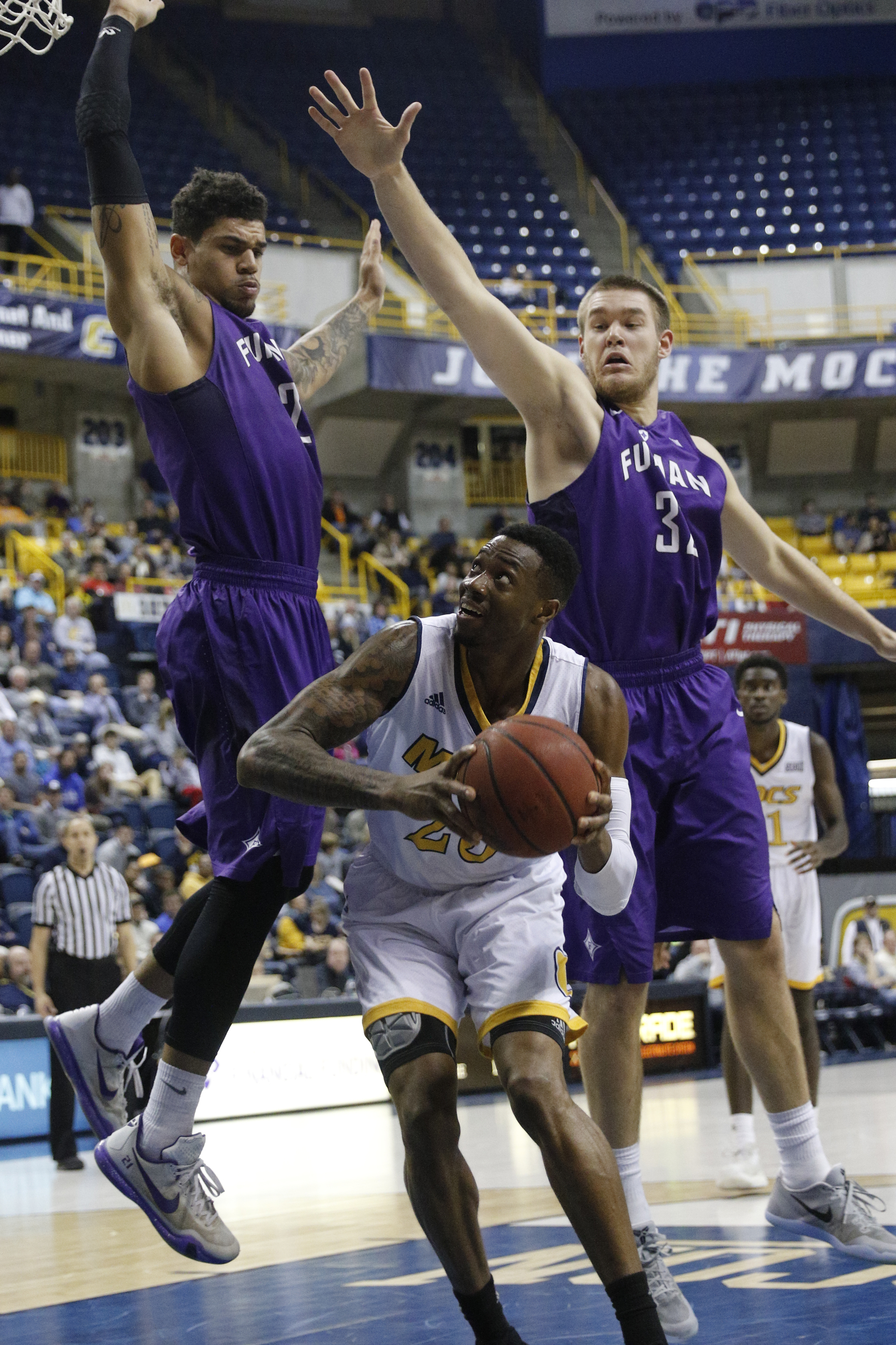 UTC forward Tre' McLean tries to find room for a shot between Furman's Matt Rafferty, right, and Kris Acox, left, during the Mocs' home basketball game against Furman at McKenzie Arena on Saturday, Jan. 7, 2017, in Chattanooga, Tenn.