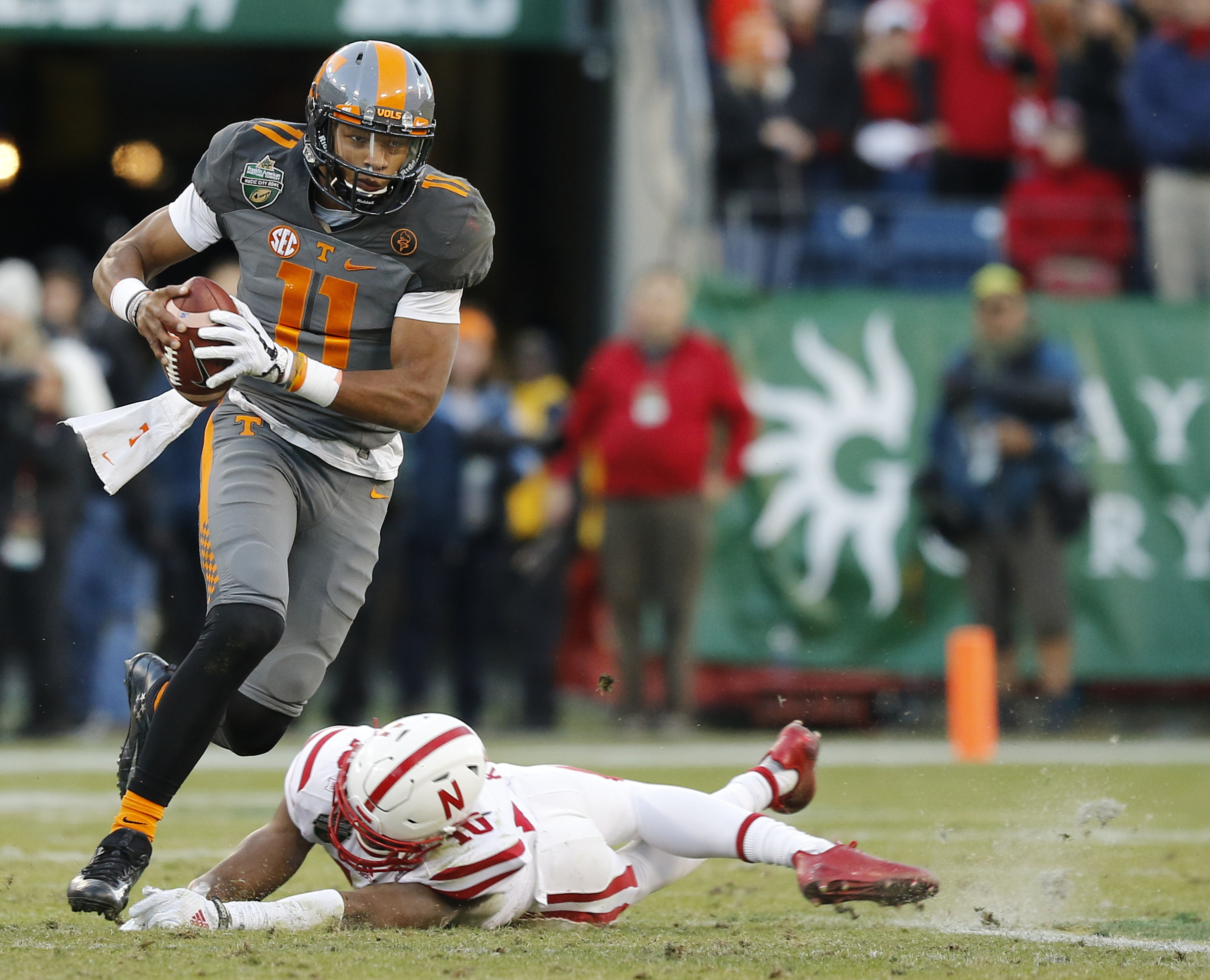 Tennessee quarterback Joshua Dobbs breaks around Nebraska defender Joshua Kalu in the first half of the Vols' Music City Bowl game against the Nebraska Cornhuskers at Nissan Stadium on Friday, Dec. 30, 2016, in Nashville, Tenn. Tennessee won 38-24.