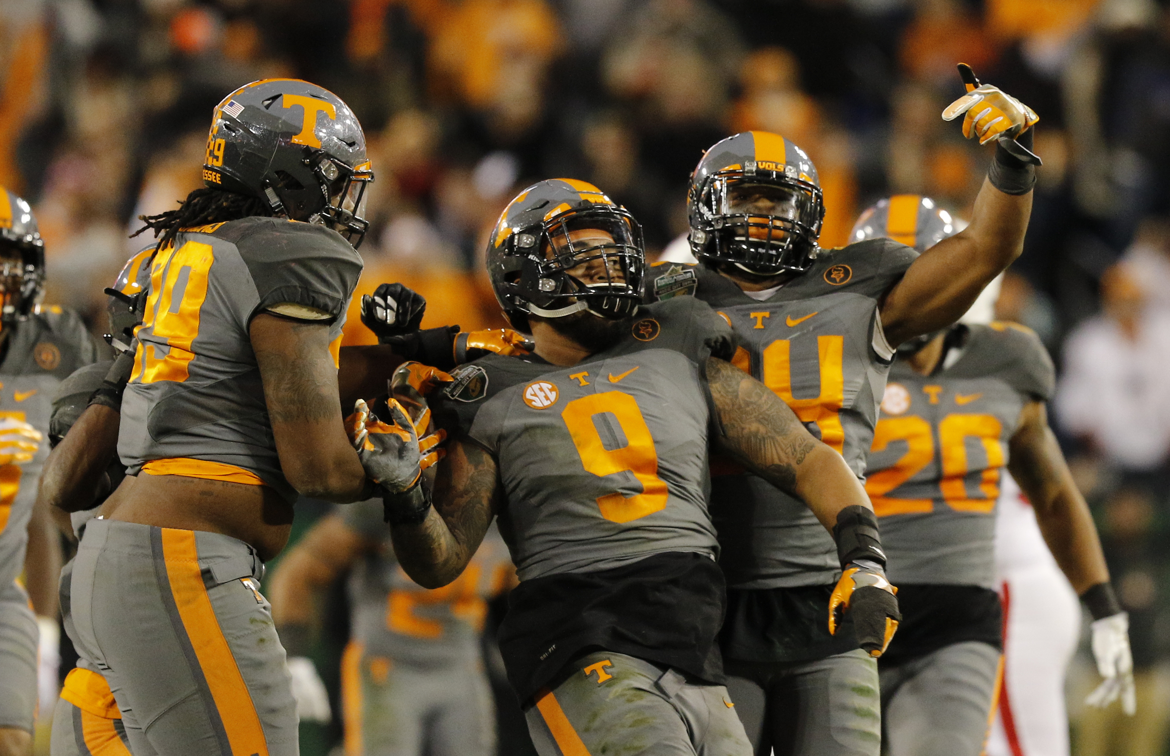Teammates celebrate after Tennessee defensive end Derek Barnett, center, broke Reggie White's record for sacks in the second half of the Vols' Music City Bowl win over Nebraska. Barnett heads a group of Vols expected to be selected in the 2017 NFL draft.