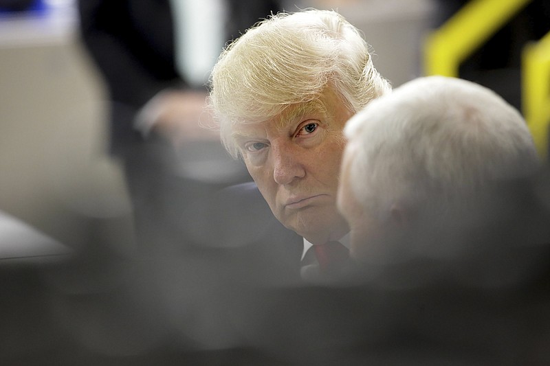 President-elect Donald Trump listens to Vice President-elect Mike Pence at the Carrier plant in Indianapolis, on Dec. 1, 2016. Days after visiting the plant, Trump took to Twitter to warn businesses thinking about moving jobs abroad that there will be a 35 percent tax levied against goods brought back for sale.