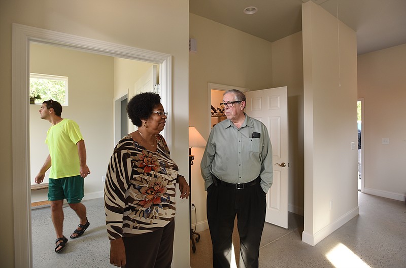 Joyce Smith, center, and Ken Gross, right, talk as they tour the tiny house on Willow Street on Thursday, October 8, 2015, as Nathan Brown, left, looks around.