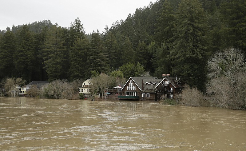 
              The Russian River flows just below cabins and a hotel Monday, Jan. 9, 2017, in Monte Rio, Calif. A massive storm system stretching from California into Nevada lifted rivers climbing out of their banks, flooded vineyards and forced people to evacuate after warnings that hillsides parched by wildfires could give way to mudslides. (AP Photo/Eric Risberg)
            