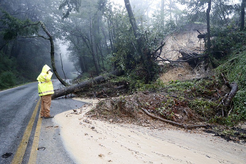 
              A Santa Clara County Roads and Airport Department worker responds to the scene of downed tree and mudslide on Summit Road in the Santa Cruz Mountains, Calif., Sunday, Jan. 8, 2017. Rivers are rising and winds are whipping up as a massive storm arrives in Northern California and is expected to push into Nevada by the evening. (Josie Lepe/Bay Area News Group via AP)
            