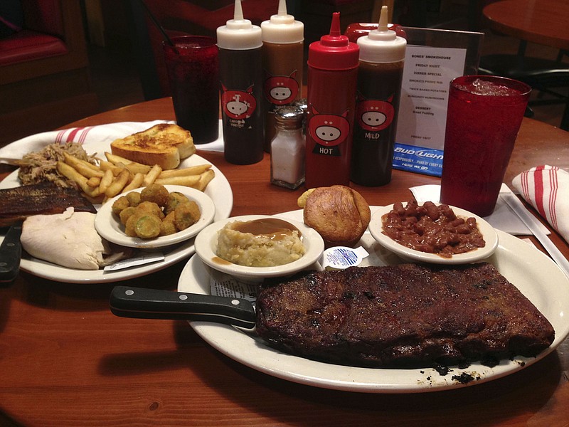 Bones' Smokehouse's combination platter, at left, includes Texas toast, dry-rubbed St. Louis-style ribs, smoked turkey, pulled pork, french fries and fried okra for $12.95. At right, a rib platter comes with a half-rack of dry-rubbed St. Louis-style ribs, mashed potatoes and gravy, spicy red beans and cornbread for $14.95.