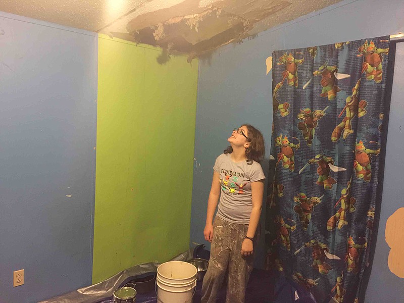 Sophia Johnson, 12, surveys the hole in her bedroom ceiling.