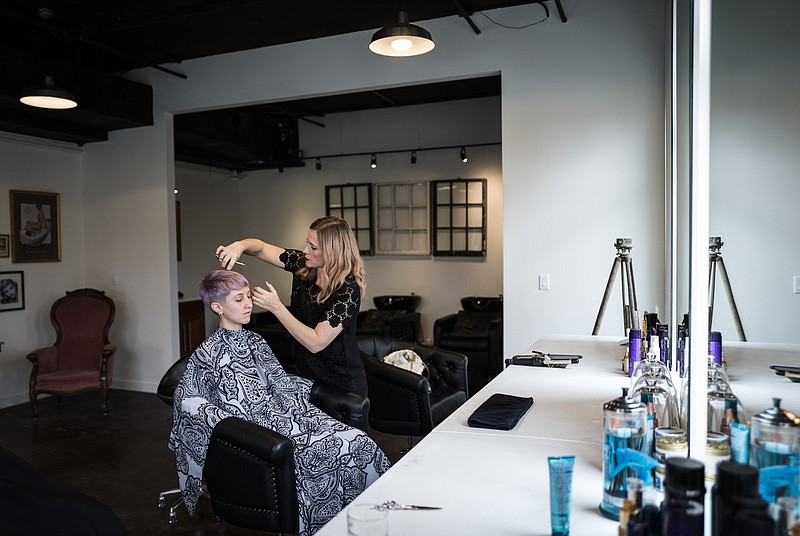 Owner Lisa Stephenson Jones cuts Elizabeth Sindler Crawford's hair at EV1 Barbershop & Salon on Cowart Street on Thursday, Jan. 12, 2017, in Chattanooga, Tenn. The new luxury salon offers straight razor shaves, alcoholic beverages to customers, and a variety of stylings and haircuts.