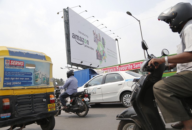 
              Motorists ride past a hoarding advertising an Amazon product in Bangalore, India, Thursday, Jan. 12, 2017. India's foreign minister has demanded an apology from online retail giant Amazon.com Inc. for selling doormats depicting the Indian flag through its Canadian retail website. (AP Photo/Aijaz Rahi)
            