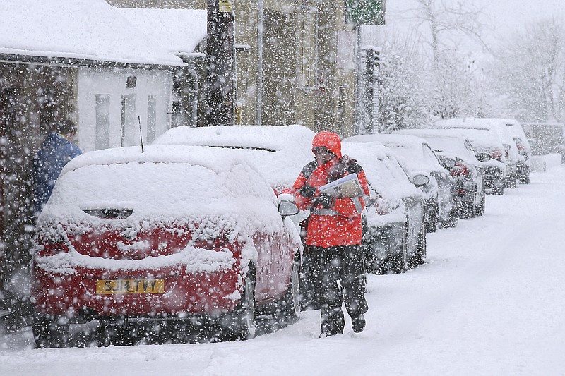 
              A postman struggles in the snow while making deliveries in Stirling, Scotland, Thursday, Jan. 12, 2017. Snow showers and strong winds are expected across Scotland, Northern Ireland, Wales and the north of England on Thursday. (Andrew Milligan/PA via AP)
            