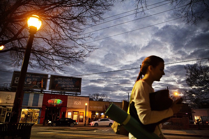 
              ADVANCE FOR USE TUESDAY, JAN. 17, 2017 AND THEREAFTER-A woman heads to a yoga class as dusk falls in East Atlanta, Ga., in Dekalb County, Wednesday, Jan. 11, 2017. The county is a Democratic stronghold east of downtown Atlanta. Hillary Clinton won four out of five DeKalb votes, capitalizing on a heavy African-American population, a burgeoning Hispanic community and a bevy of white liberals, many of them from elsewhere. (AP Photo/David Goldman)
            