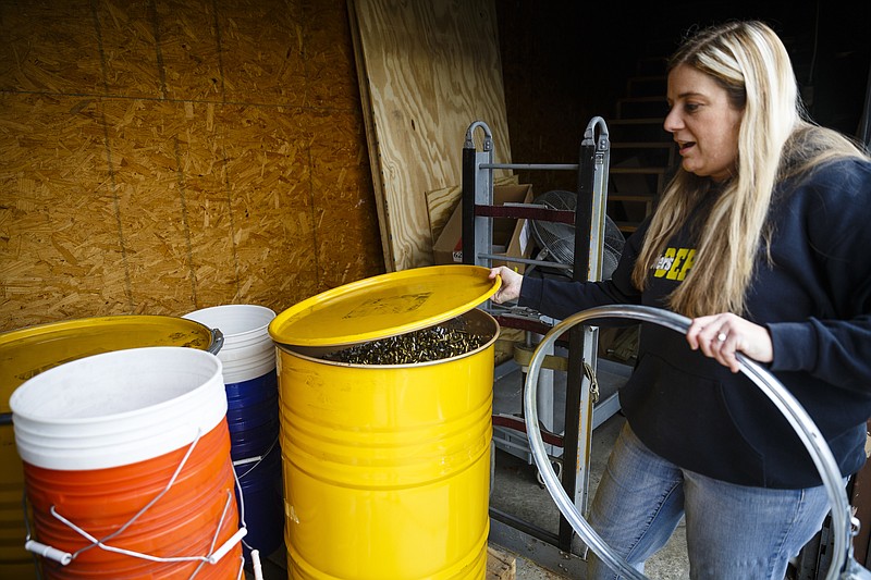 Co-owner Amiee Smith opens a container with spent brass that was at the center of a Thursday Chattanooga police bust at Shooter's Depot on Friday, Jan. 13, 2017, in Chattanooga, Tenn. Shooter's Depot was the site of a Chattanooga police bust of a brass-buying scam.