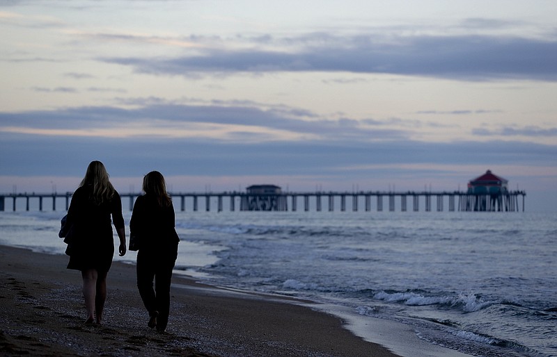 
              ADVANCE FOR USE TUESDAY, JAN. 17, 2017 AND THEREAFTER- Catherine Johnson, left, and her mother, Bridget, walk in the sand along the shore of Huntington Beach, Calif., on Wednesday, Jan. 4, 2017. "I'm excited because for the past eight years... we haven't had anything done because of the gridlock in Washington," says Catherine, 17, who served as Orange County chair of Students for Trump. "A lot of people will get on board once they see that we're doing, instead of like crazy things, we're doing productive things that helps the country as a whole rather than helping one group." Her mother, who is active in local Republican politics, agrees. "Trump is a very hard worker and he's really going to get some work done rather than being the typical politician that just kicks the can down the road." (AP Photo/Chris Carlson)
            