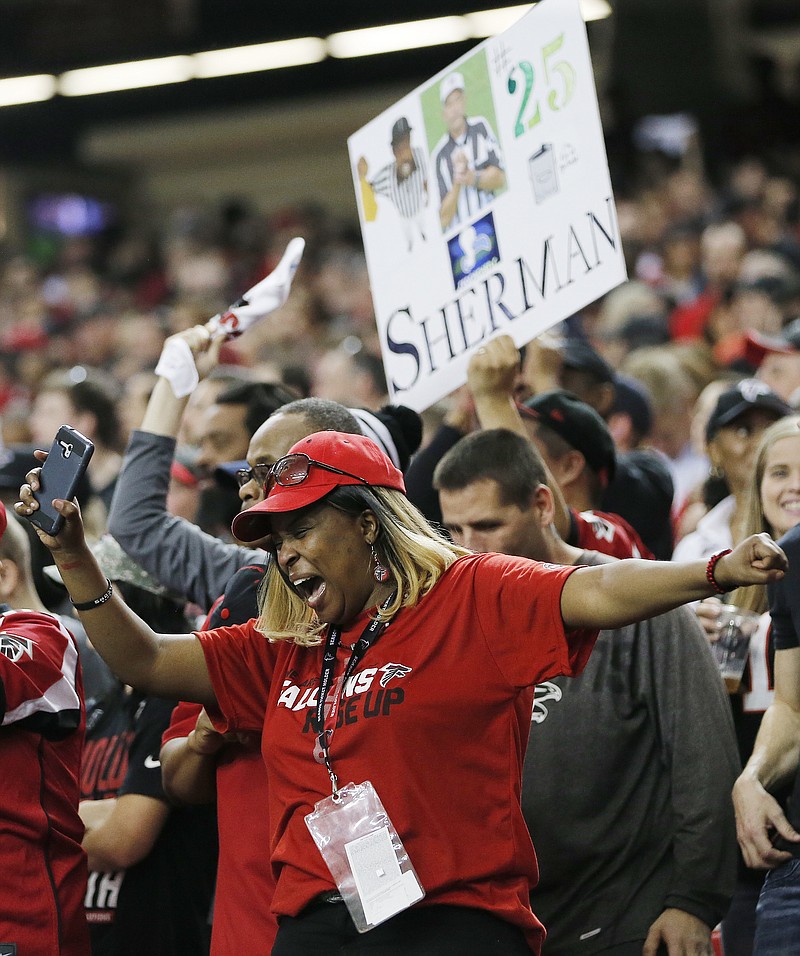 An Atlanta Falcons fan cheers as the team runs onto the field before the first half of an NFL football NFC divisional playoff game between the Atlanta Falcons and the Seattle Seahawks, Saturday, Jan. 14, 2017, in Atlanta. (AP Photo/John Bazemore)