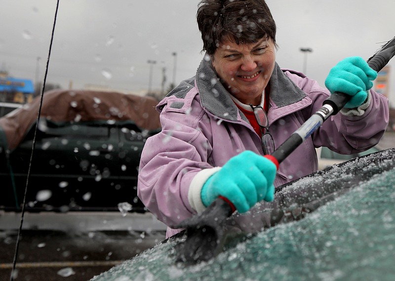 
              Mary Zinser scrapes a thick layer of ice off her windshield, Friday, Jan. 13, 2017 in Arnold, Mo. A thick glaze of ice covered roads from Oklahoma to southern Illinois on Friday amid a winter storm that caused numerous wrecks, forced school cancellations, grounded flights and prompted dire warnings for people to stay home. (David Carson/St. Louis Post-Dispatch via AP)
            