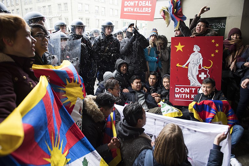 
              People protest in front of the police for a free Tibet and against the visit of China's President Xi Jinping  in Bern, on Sunday, Jan. 15, 2017. (Anthony Anex/Keystone via AP)
            