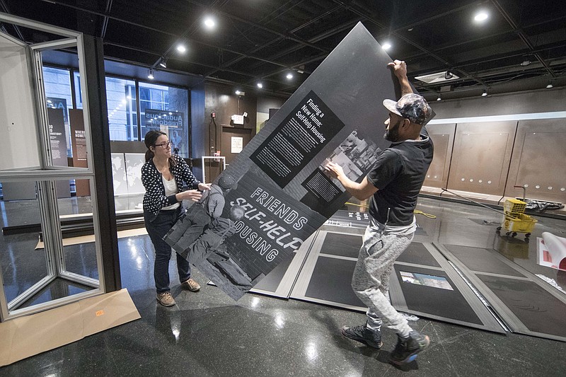 
              Elizabeth Tinker and Noah Smalls instal an exhibit at the African American Museum in Philadelphia, Tuesday, Jan. 10, 2017. The American Friends Service Committee is celebrating 100 years of activism with an exhibit called "Waging Peace. " (AP Photo/Matt Rourke)
            