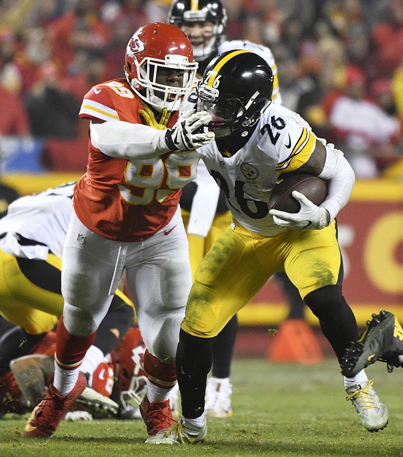 
              Pittsburgh Steelers running back Le'Veon Bell (26) runs from Kansas City Chiefs defensive tackle Rakeem Nunez-Roches during the first half of an NFL divisional playoff football game Sunday, Jan. 15, 2017, in Kansas City, Mo. (AP Photo/Ed Zurga)
            