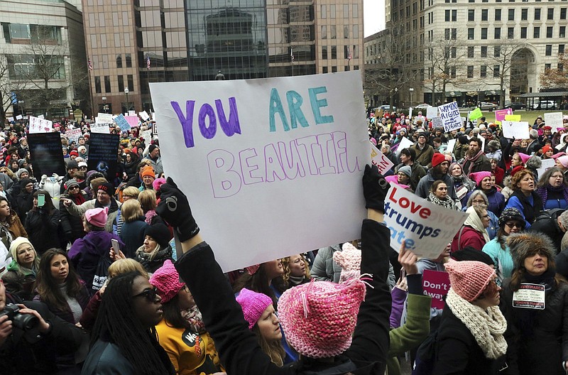 Kylie Harwell holds a sign reading "You are beautiful" as participants gather near the Ohio Statehouse steps during the Womens March on Washington - Ohio Sister March on Washington in Columbus, Ohio on Sunday, Jan. 15, 2017. (Brooke LaValley/The Columbus Dispatch via AP)