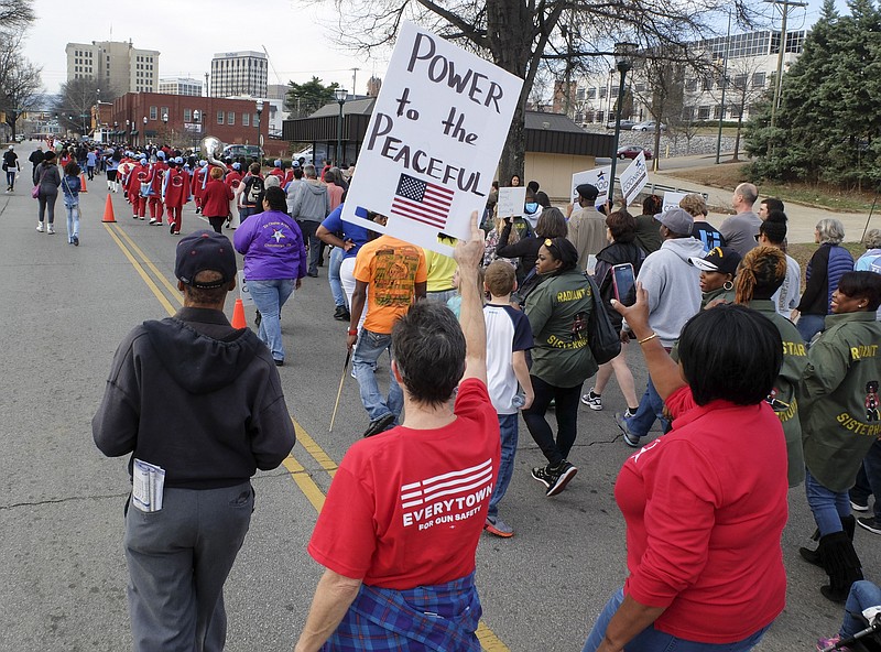 Lissa Dearing holds her sign as she marches with hundreds on M.L. King Blvd. in the annual King March in downtown Chattanooga.