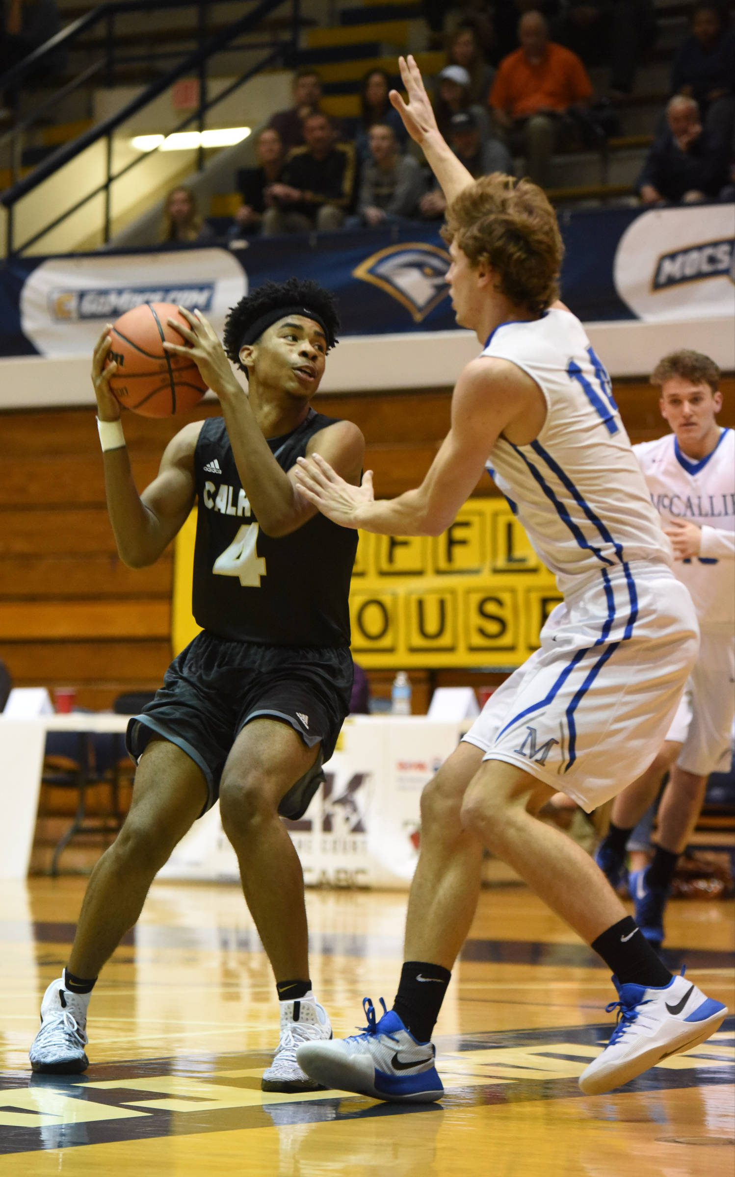 Calhoun's Kaylan Aker (4) looks for room to shoot as McCallie's Seth Clark (14) defends in the King of the Courts tournament Monday night at Maclellan Gym.